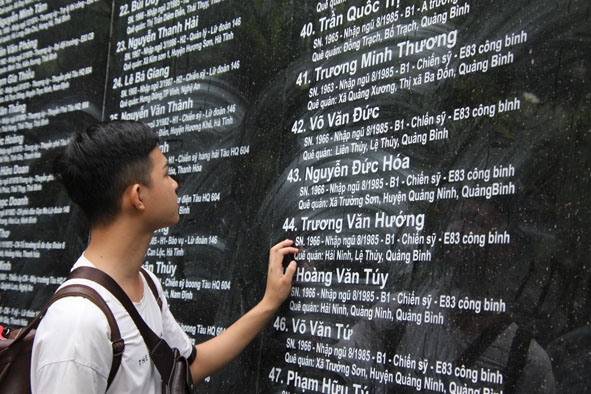 Một bạn trẻ  trước bia đá  khắc tên  các liệt sĩ  trong trận  Gạc Ma. 
