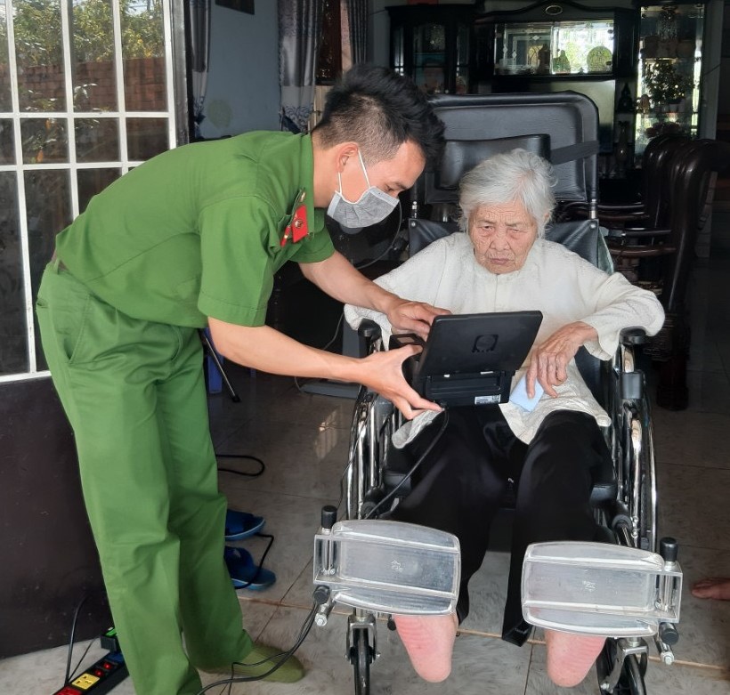 Cán bộ, chiến sĩ Công an huyện Cư Kuin làm thủ tục cấp căn cước công dân cho Mẹ Việt Nam Anh hùng Nguyễn Thị Đơm.