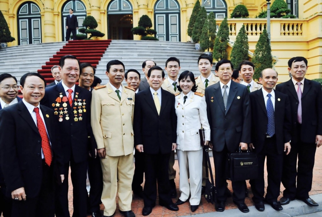 Anh hùng Lực lượng vũ trang nhân dân, Đại tá Phan Thị Ngọc Tươi (giữa) chụp hình lưu niệm cùng Chủ tịch nước Nguyễn Minh Triết trong chuyến thăm Hà Nội năm 2011. (Ảnh do nhân vật cung cấp)