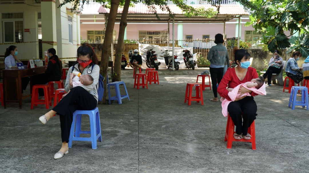 Người dân ngồi giãn cách chờ tiêm chủng tại Trạm Y tế phường Tân Lợi. Ảnh: Quang Nhật