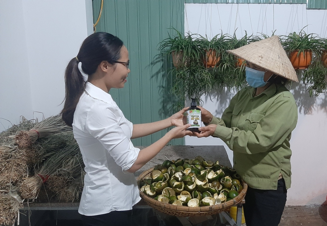 Chị Bùi Thị Hòa (bên trái) đổi sản phẩm lấy phế phẩm hữu cơ.