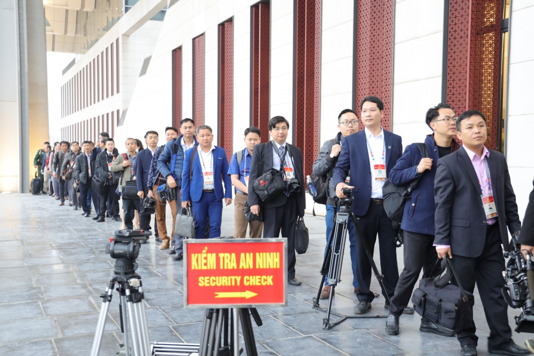 Đội ngũ phóng viên, nhà báo thực hiện các bước kiểm tra an ninh để tác nghiệp tại Đại hội XIII. 