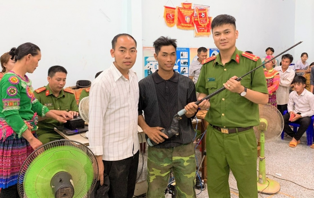 Người dân xã Cư Pui tự nguyện giao nộp súng tự chế cho lực lượng công an tại điểm làm CCCD lưu động.