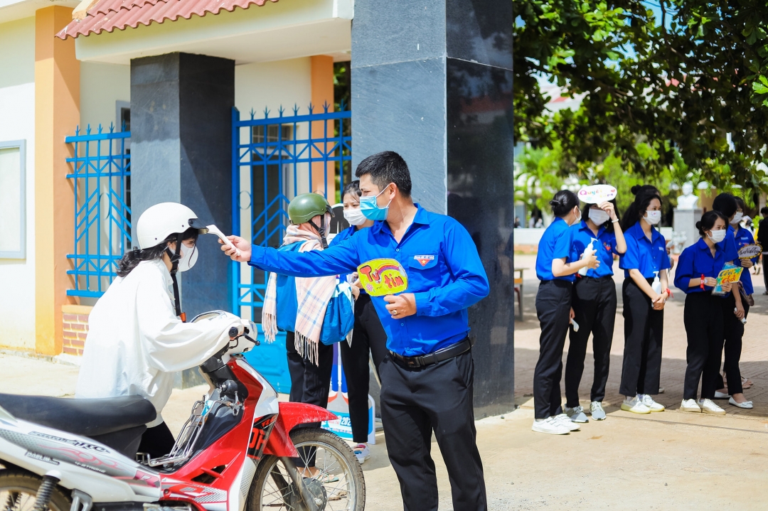 Lực lượng thanh niên tình nguyện hỗ trợ đo thân nhiệt cho thí sinh tại điểm thi Trường THPT Lê Hồng Phong, xã Ea Phê