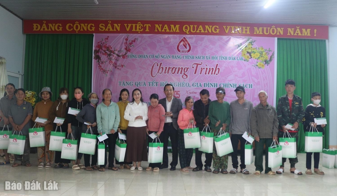 Đại diện lãnh đạo Ngân hàng Chính sách xã hội Chi nhánh Đắk Lắk và huyện Buôn Đôn tặng quà cho người dân.