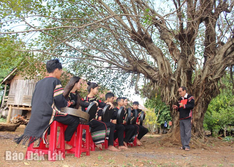 Nghệ sĩ ưu tú Vũ Lân hướng dẫn và  truyền dạy kỹ năng thực hành đánh chiêng cho các học viên ở buôn Tuôr, xã Hòa Phú, TP. Buôn Ma Thuột