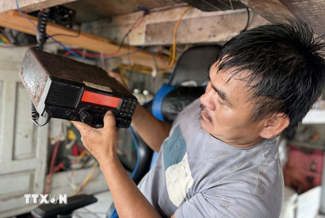 Ngư dân kiểm tra thiết bị giám sát hành trình trên biển trước khi ra khơi đánh bắt thủy sản. Ảnh: TTXVN