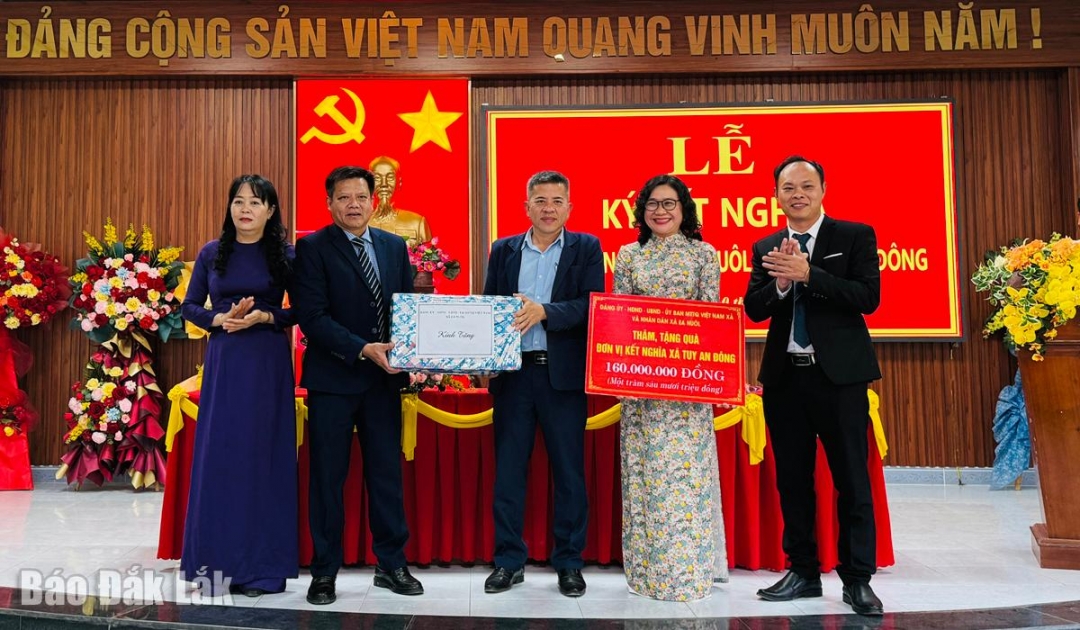 Lãnh đạo xã  Ea Nuôl trao tiền hỗ trợ cho lãnh đạo xã Tuy An Đông.