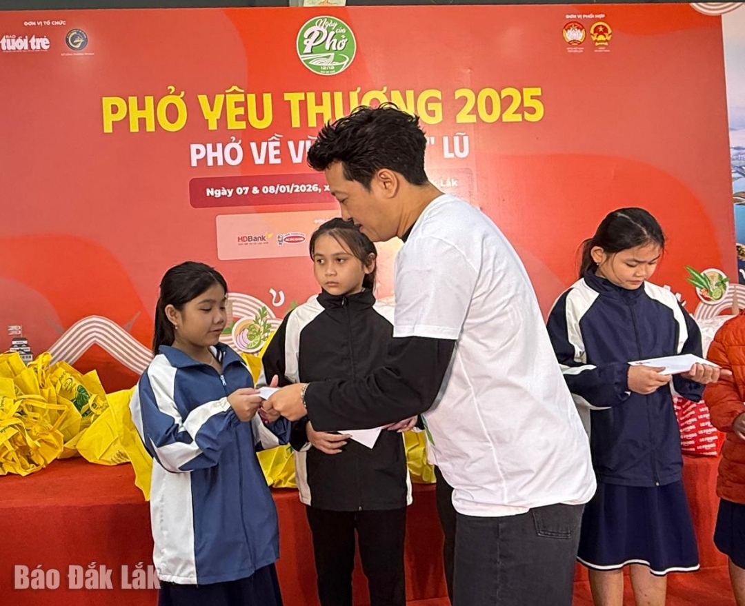 Nghệ sĩ Trường Giang trao quà cho các em học sinh.