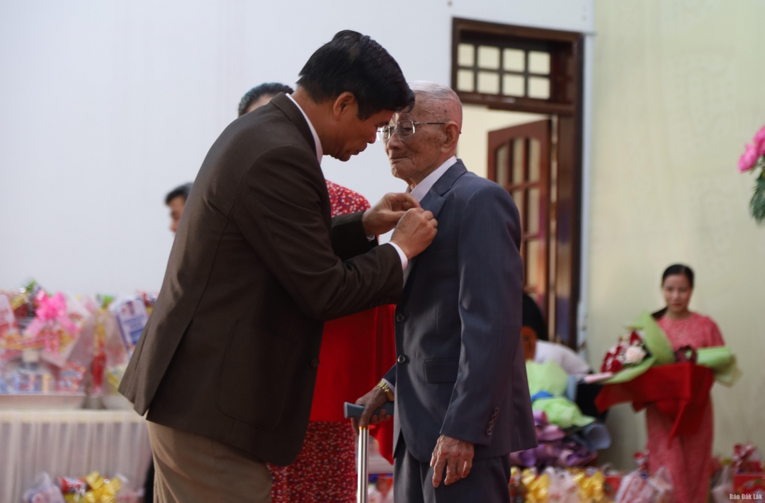 Đồng chí Đỗ Quốc Hương, Bí thư Huyện ủy Krông Bông trao Huy hiệu Đảng cho đảng viên 65 năm tuổi Đảng.