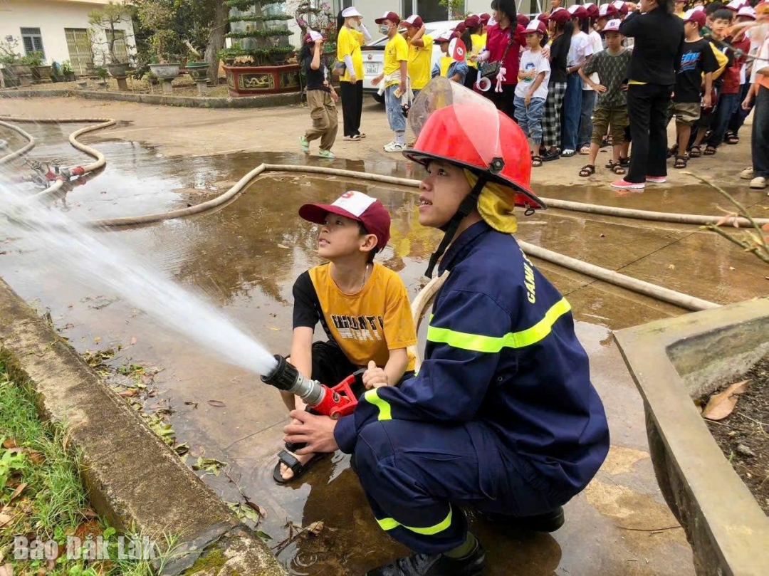 Cảnh sát phòng cháy chữa cháy và cứu nạn cứu hộ hướng dẫn học sinh tham gia các lớp trải nghiệm sử dùng vòi rồng chữa cháy.