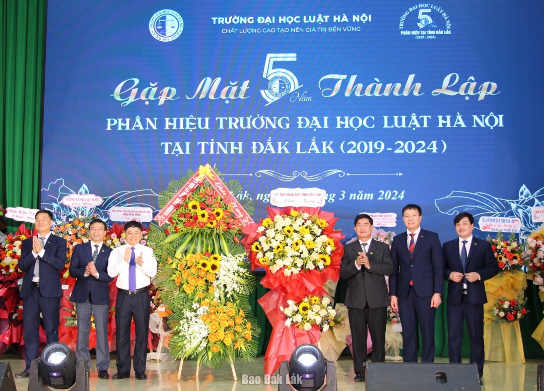 Phó Bí thư Thường trực Tỉnh uỷ Phạm Minh Tấn và Phó Chủ tịch UBND tỉnh Nguyễn Thiên văn tặng hoa chúc mừng Phân hiệu Trường Đại học Luật Hà Nội tại tỉnh Đắk Lắk.