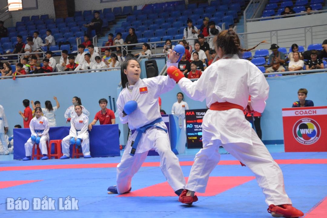 Vận động viên Trần Thị Huyền Trang (đai xanh) của chủ nhà Đắk Lắk thi đấu nội dung kumite đồng đội và đoạt huy chương vàng.