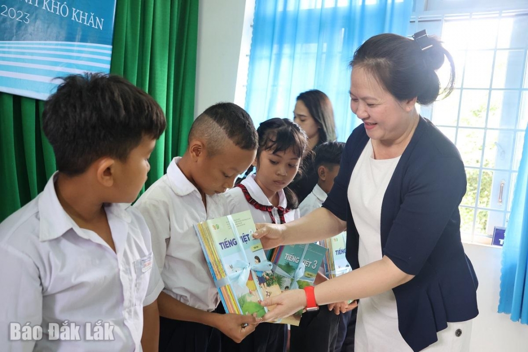 Phó Giám đốc Sở Giáo dục và Đào Tạo Lê Thị Kim Oanh, tặng sách giáo khoa cho Học sinh xã Cư Êbur (thành phố Buôn Ma Thuột) nhận sách từ