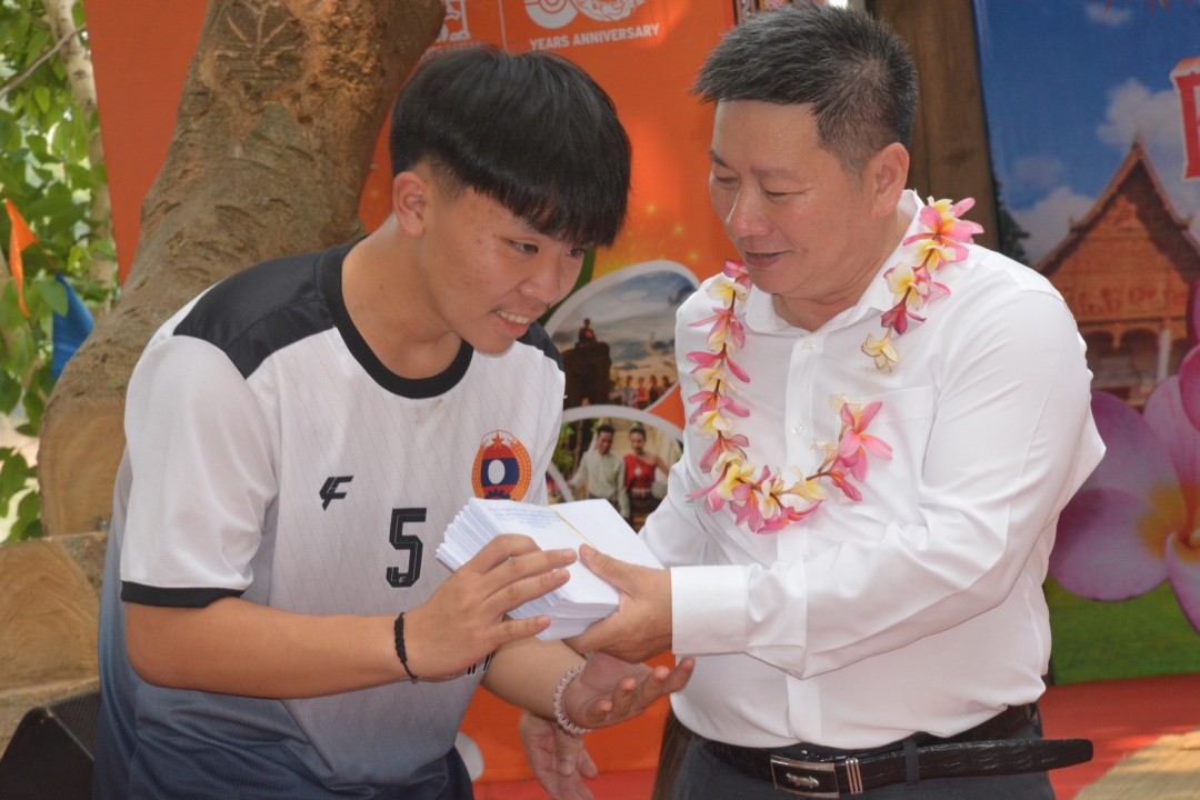 Chủ tịch Hội hữu nghị Việt Nam - Lào tỉnh Lê Văn Nghĩa trao quà tặng học sinh Lào.