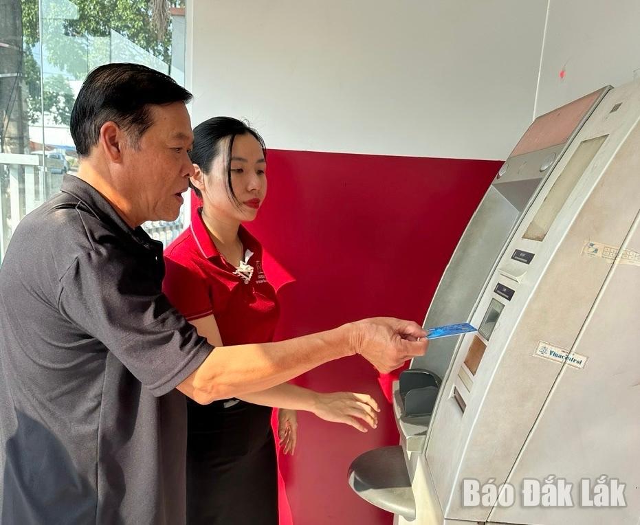 Cán bộ Agribank Chi nhánh huyện Krông Bông (trực thuộc Agribank Đắk Lắk) hướng dẫn khách hàng sử dụng dịch vụ tại ATM của Agribank.