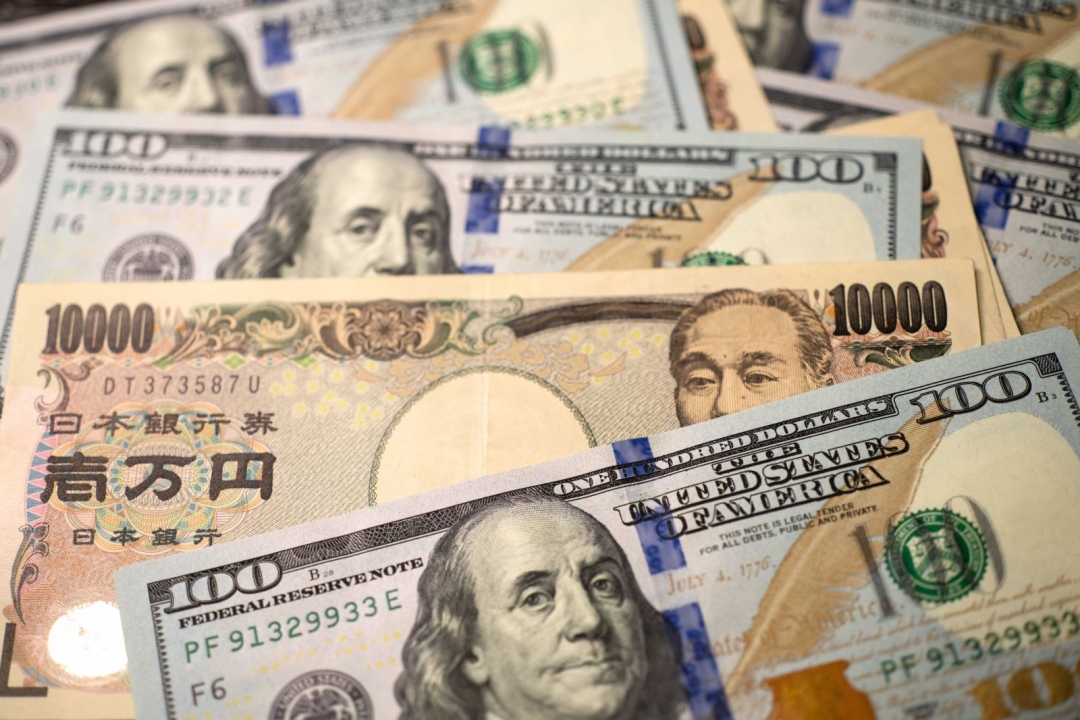 Đồng tiền 10.000 yen của Nhật Bản và đồng 100 USD của Mỹ. Ảnh: THX/TTXVN