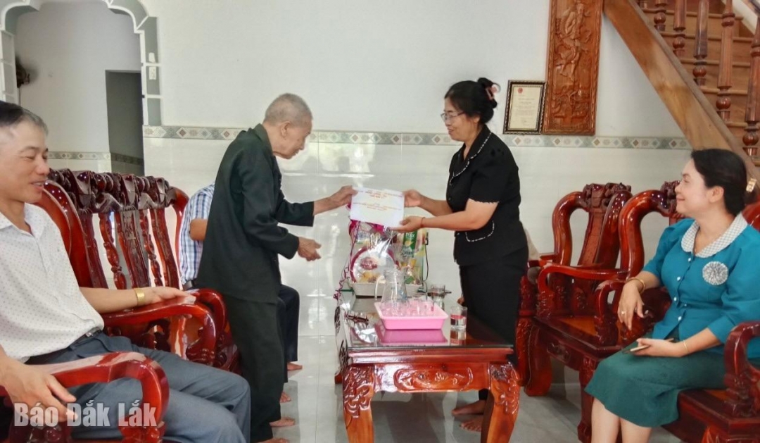 Đồng chí H’ Kim Hoa Byă tặng quà cho cựu thanh niên xung phong Hoàng Công Khoan (SN 1929, trú tại thôn Liên Kết 2, xã Buôn Tría).