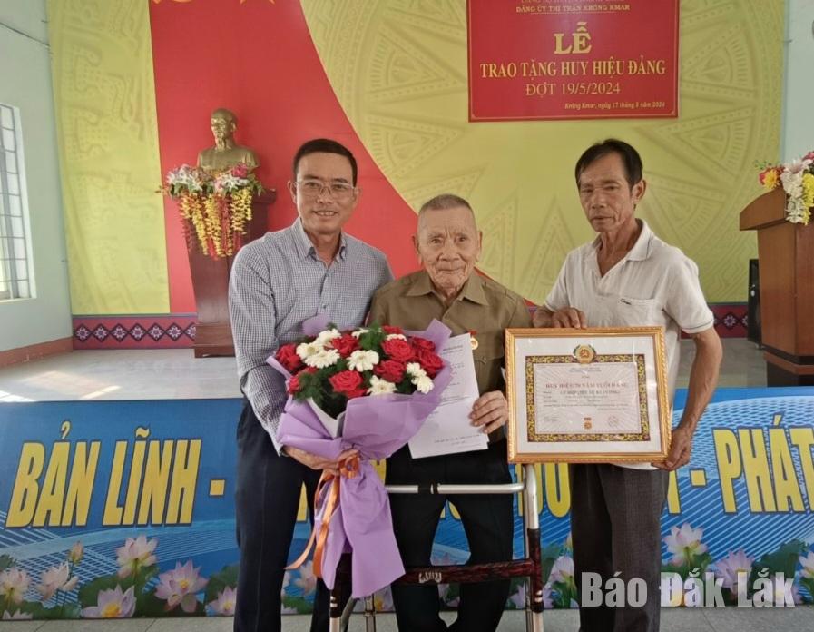 Phó Bí thư Huyện ủy, Chủ tịch UBND huyện Krông Bông Lê Văn Long trao Huy hiệu 70 năm tuổi Đảng cho đảng viên Lữ Bá Vương (Đảng bộ thị trấn Krông Kmar).