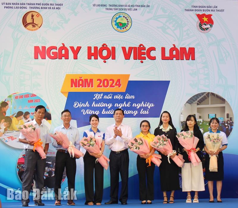 Lãnh đạo Sở Lao động, thương binh và xã hội tặng hoa các doanh nghiệp tham gia tuyển dụng tại ngày hội. 