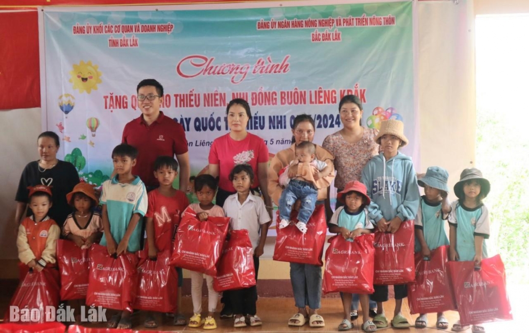 Đại diện các đơn vị tặng quà cho thiếu nhi tại buôn kết nghĩa Liêng Krắk (xã Krông Nô, huyện Lắk).