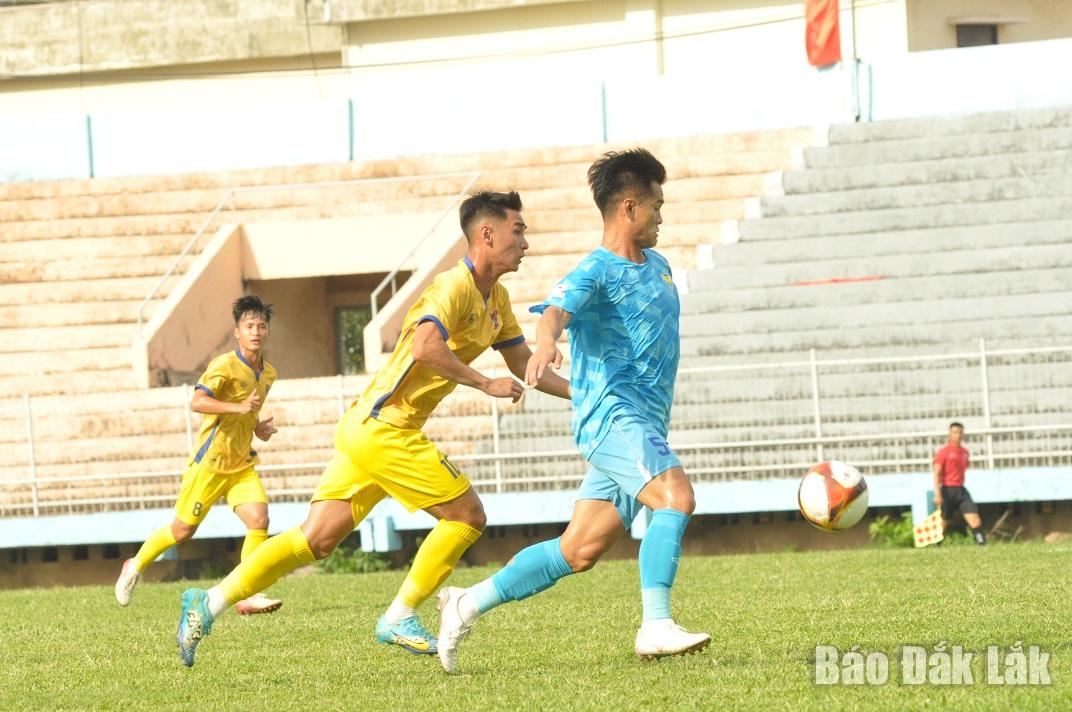 Cựu cầu thủ Câu lạc bộ Bóng đá Đắk Lắk Bùi Hoàng Mỹ (trang phục xanh) cản phá pha tấn công của các cầu thủ áo vàng chủ nhà.