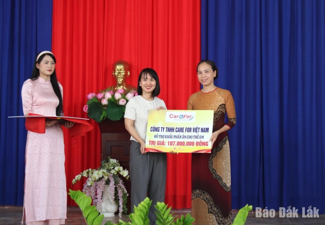 Đại diện Công ty TNHH Care for Việt Nam trao biểu trưng hỗ trợ khẩu phần ăn cho Trường Tiểu học Ea Hồ.