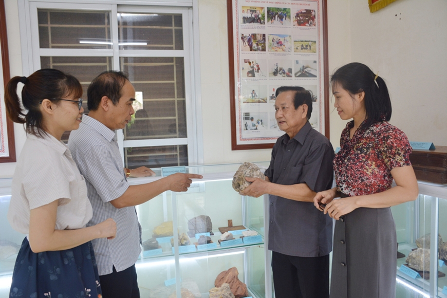 Ông Phan Văn Mẫn (thứ hai, từ phải sang) giới thiệu mẫu quặng do đồng chí Trần Đức Lương và các đồng nghiệp tìm được năm 1974. Ảnh: HỒNG SÁNG