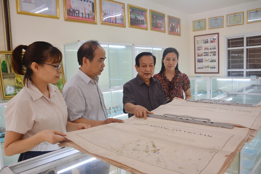  Ông Phan Văn Mẫn (thứ hai, từ phải sang) giới thiệu về bộ bản đồ địa chất Việt Nam, bản đồ khoáng sản Việt Nam do đồng chí Trần Đức Lương và nhà địa chất Nguyễn Xuân Bao là đồng chủ biên. Ảnh: HỒNG SÁNG