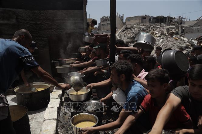 Người dân Palestine nhận thức ăn cứu trợ tại trại tị nạn Jabalia, miền Bắc Dải Gaza ngày 19/5/2025. Ảnh: THX/TTXVN