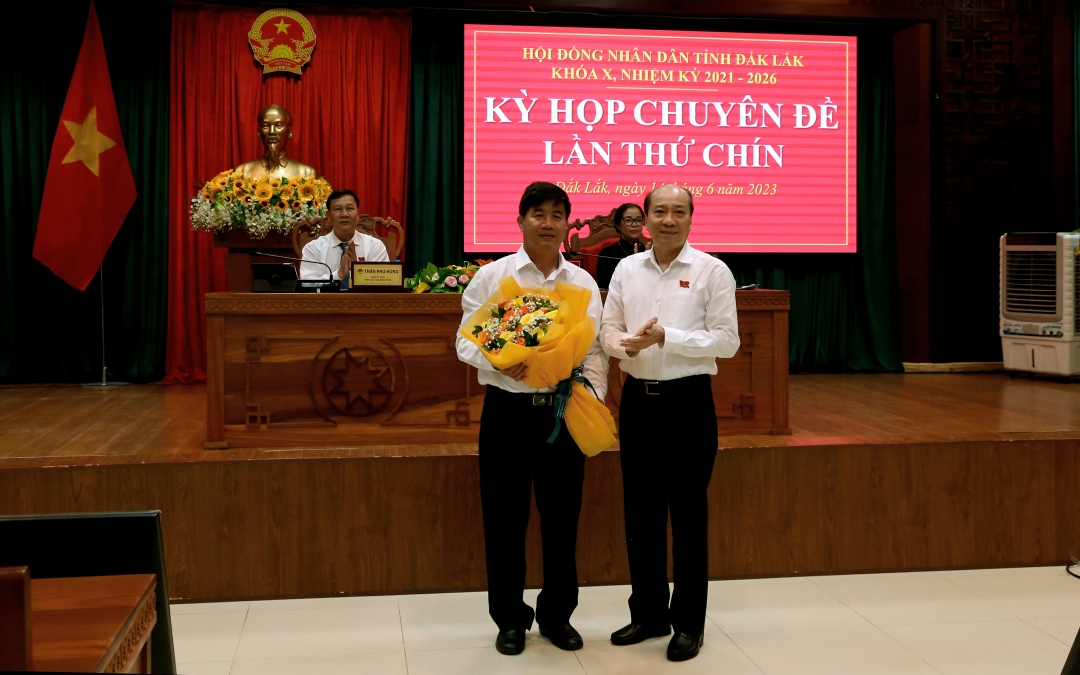 Chủ tịch UBND tỉnh Phạm Ngọc Nghị tặng hoa chúc mừng đồng chí Nguyễn Thiên Văn. Ảnh: Thế Hùng