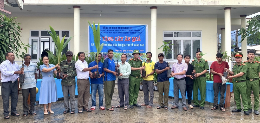 Lãnh đạo Công an huyện Lắk và đại diện UBND xã Yang Tao tặng cây giống cho người dân khó khăn.