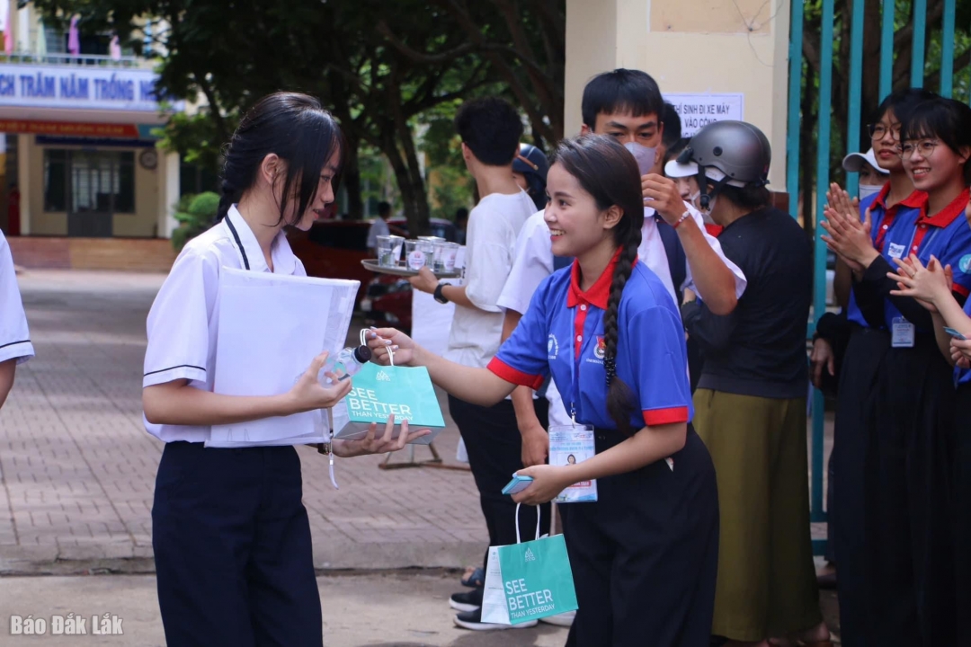 Tình nguyện viên tại Điểm thi Trường THPT Buôn Ma Thuột tặng quà động viên tinh thần thí sinh sau khi hoàn thành bài thi.