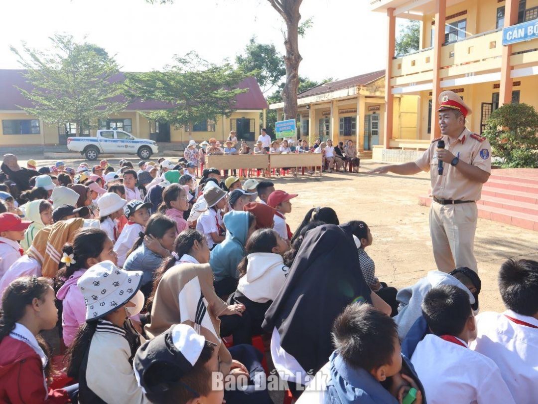 Cán bộ Đội CSGT - Trật tự (Công an huyện Krông Pắc) tuyên truyền an toàn giao thông cho học sinh trên địa bàn.