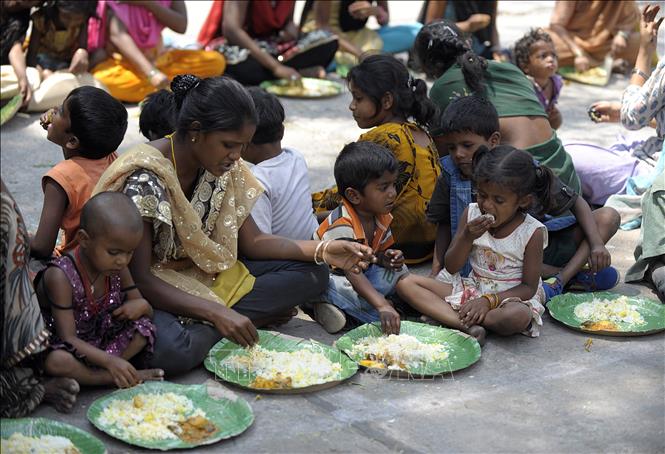 Người vô gia cư nhận thức ăn từ một chương trình cứu trợ dành cho người nghèo ở Hyderabad, Ấn Độ. Ảnh tư liệu: AFP/TTXVN