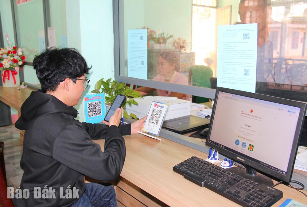 Người dân thanh toán trực tuyến khi thực hiện thủ tục hành chính tại Bộ phận tiếp nhận và trả kết quả xã Ea Yông (huyện Krông Pắc).