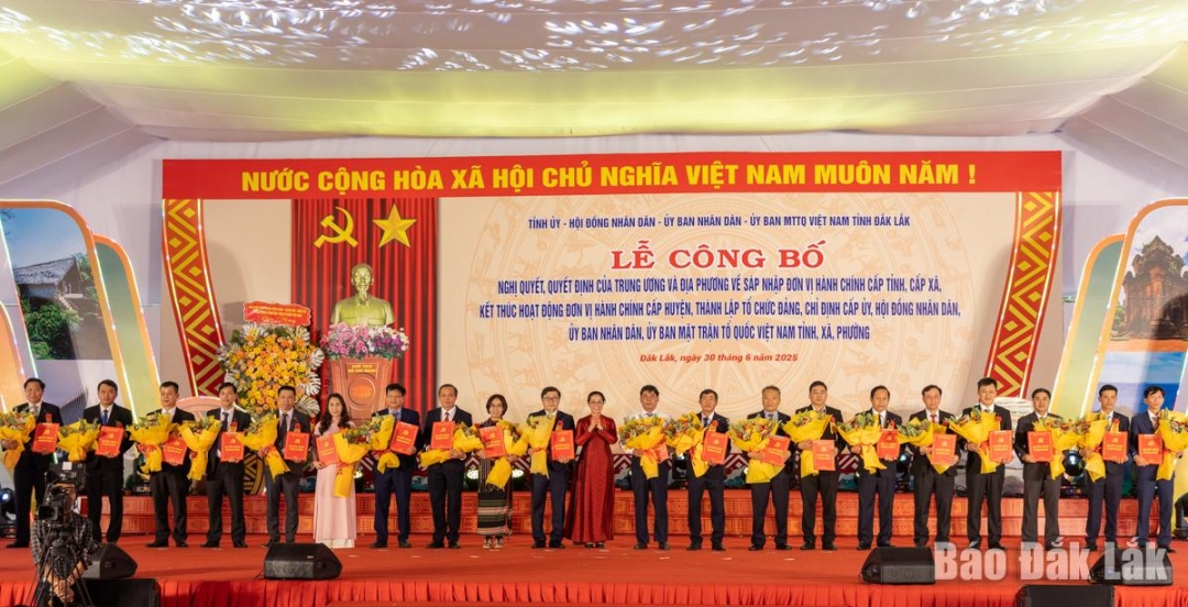 Đồng chí Huỳnh Thị Chiến Hòa, Phó Bí thư Tỉnh ủy trao quyết định và tặng hoa chúc mừng các đồng chí Bí thư xã, phường. Ảnh: N.Gia