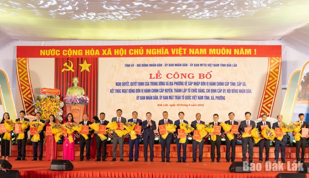 Đồng chí Đỗ Hữu Huy, Phó Bí thư Tỉnh ủy trao quyết định và tặng hoa chúc mừng các đồng chí Bí thư xã, phường. Ảnh: N.Gia