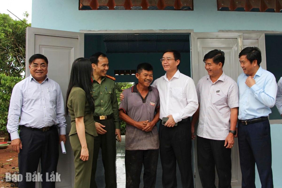 Đoàn công tác chuyện trò, thăm hỏi người dân được hỗ trợ xây nhà ở.