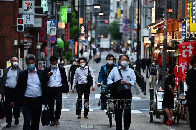 Người dân di chuyển trên một đường phố ở Tokyo, Nhật Bản. Ảnh tư liệu: AFP/TTXVN