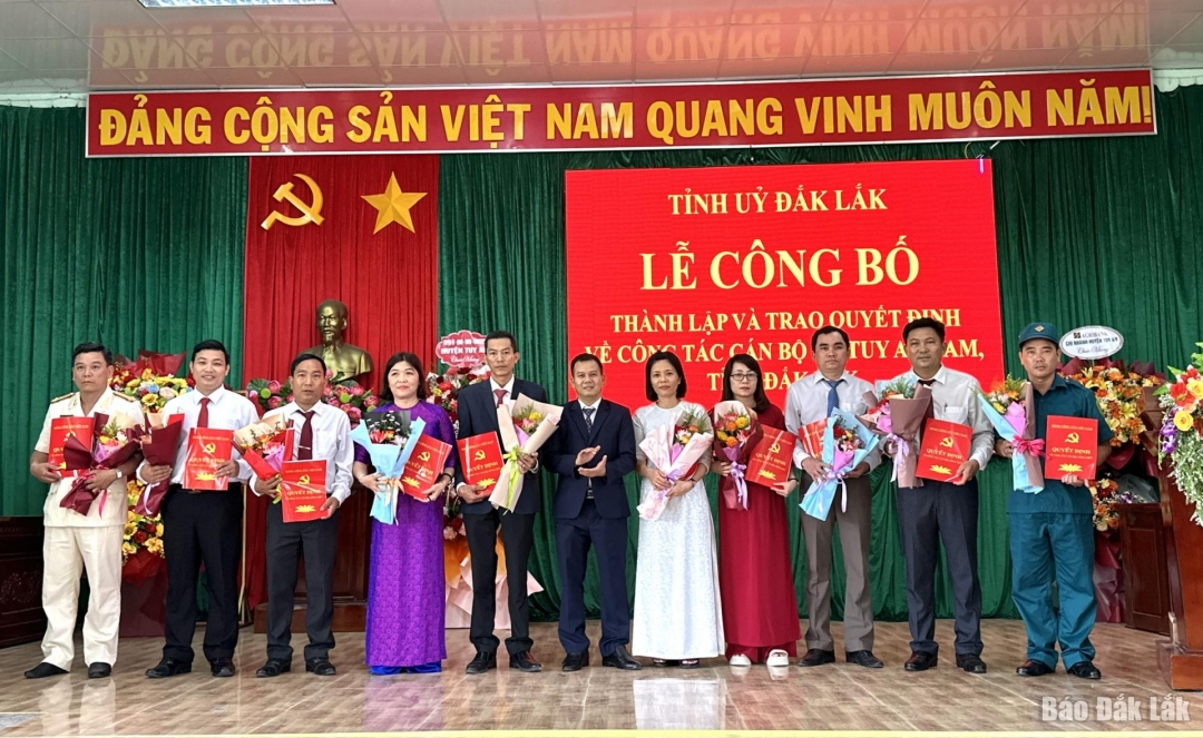 Phó Chánh Văn phòng UBND tỉnh Nguyễn Minh Hòa trao quyết định, tặng hoa cho các đồng chí Ban Thường vụ xã Tuy An Nam. Ảnh: Trần Quới