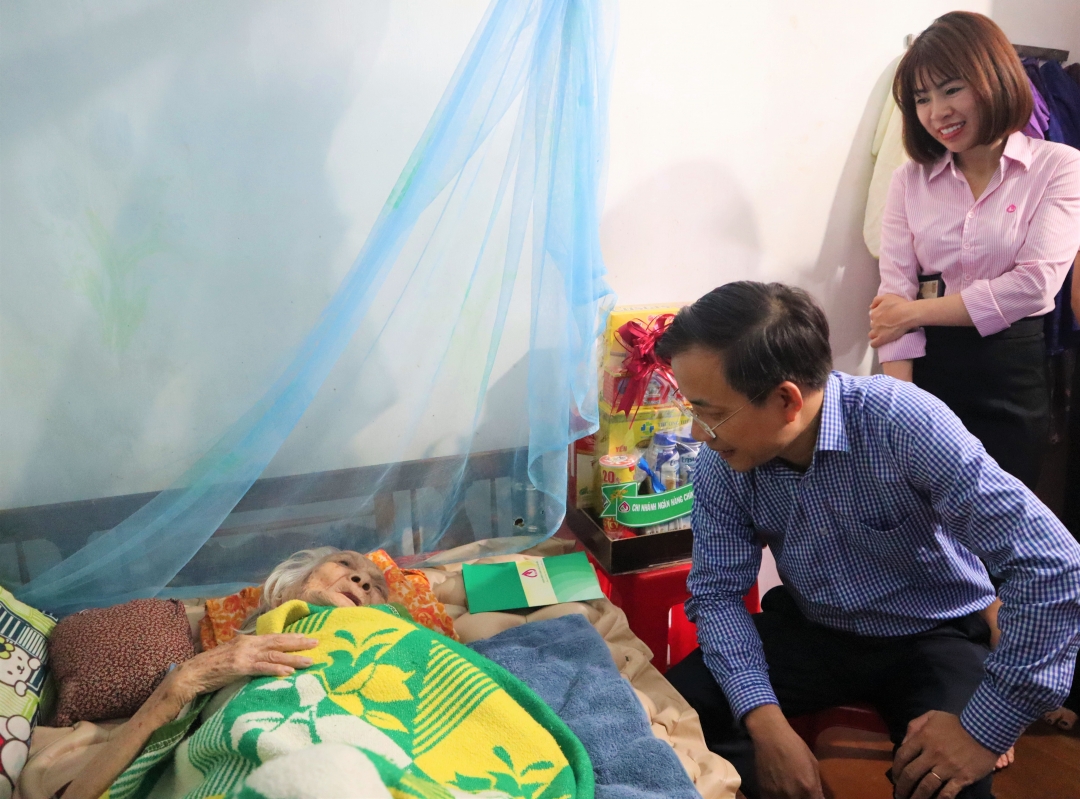 Giám đốc Chi nhánh NHCSXH tỉnh Đào Thái Hòa hỏi thăm sức khỏe của mẹ Việt Nam Anh hùng Lê Thị Bé.