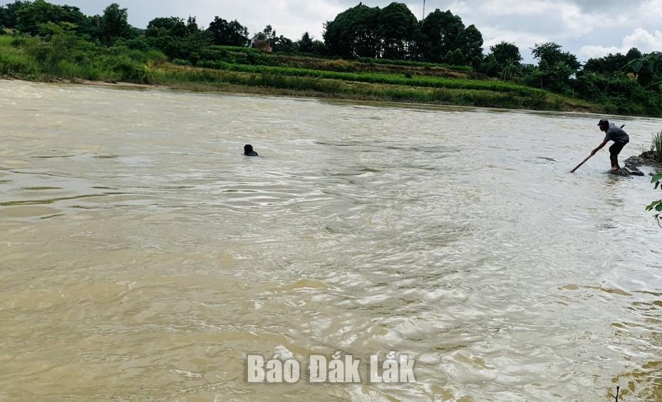 Anh Y Thanh Bing dùng thanh tre để cứu cháu bé đang bị trôi dưới nước.