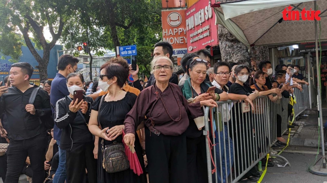 Bà Doãn Thị Trinh, 73 tuổi (Sơn Đồng, Hoài Đức, Hà Nội) \đã đến Nhà tang lễ từ sáng. 16 giờ, bà tiếp tục đứng xếp hàng chờ vào viếng. Bà là một trong những người dân đầu tiên được vào viếng Tổng Bí thư Nguyễn Phú Trọng lúc 18 giờ.