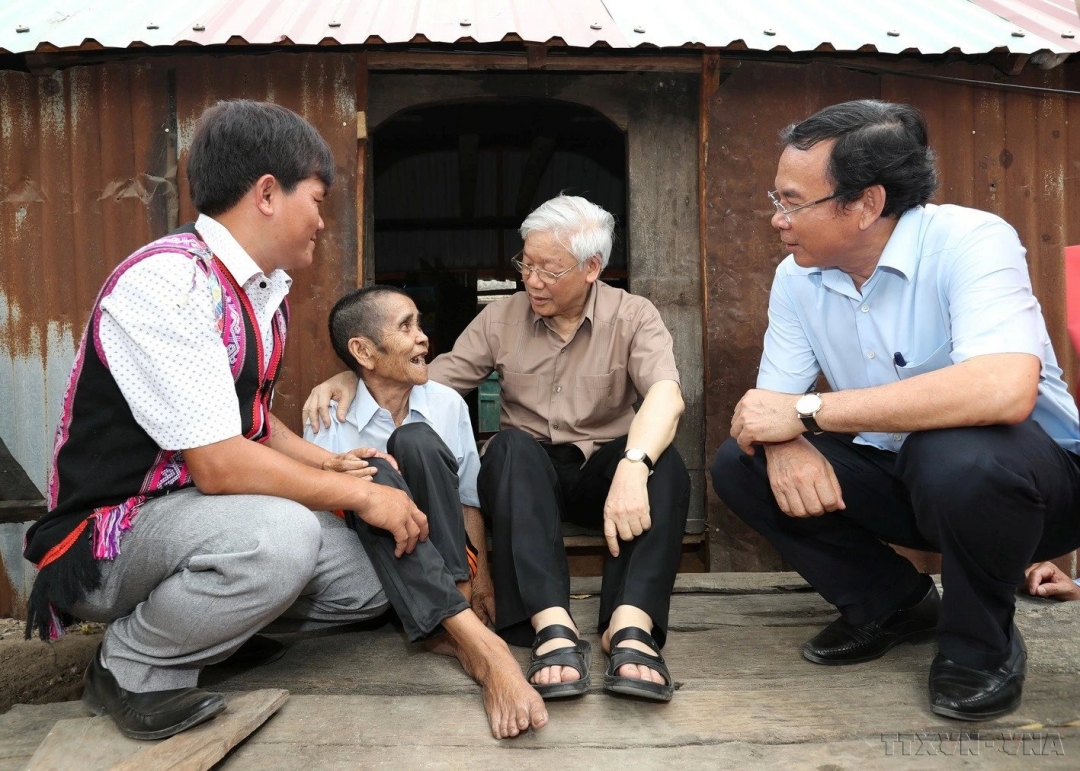 Tổng Bí thư Nguyễn Phú Trọng thăm, tặng quà thương binh Đinh Phi và vợ là Đinh Brat, hộ gia đình chính sách có hoàn cảnh đặc biệt khó khăn ở làng Tung Ke 2, xã Ayun, huyện Chư Sê, tỉnh Gia Lai. Ảnh: Trí Dũng - TTXVN