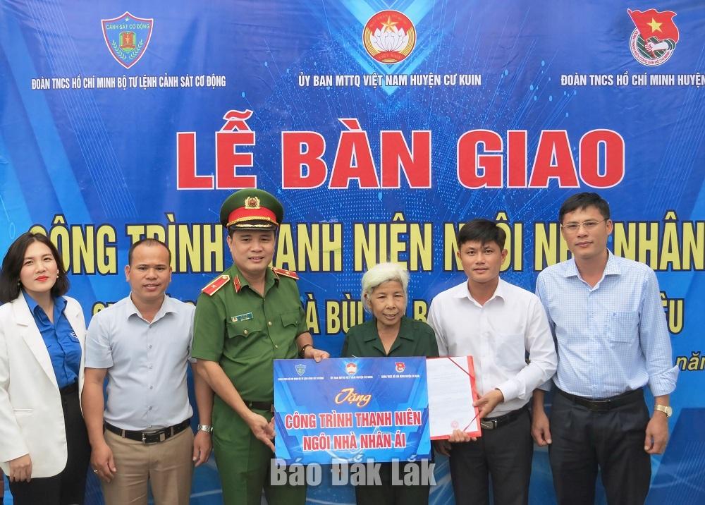 Lãnh đạo Bộ Tư lệnh Cảnh sát Cơ động và lãnh đạo Huyện ủy Cư Kuin bàn  giao nhà nhân ái cho cựu thanh niên xung phong.