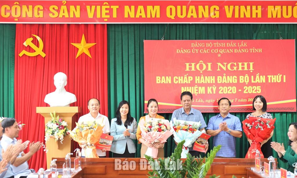 Đồng chí Lê Thị Kim Cương và Bun Thó Lào trao quyết định và tặng hoa cho các đồng chí Văn phòng Đảng ủy và Ban Tuyên giáo và Dân vận Đảng ủy.