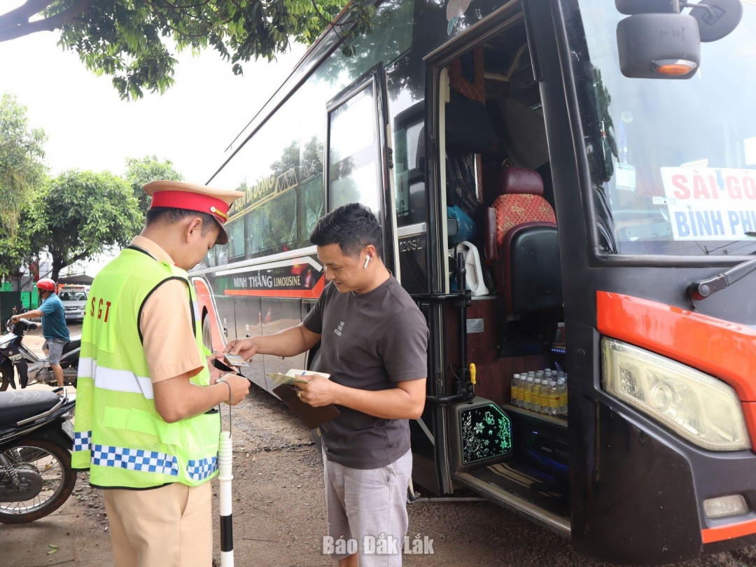 Cán bộ Phòng Cảnh sát giao thông (Công an tỉnh Đắk Lắk) kiểm tra hành chính tài xế điều khiển xe khách.