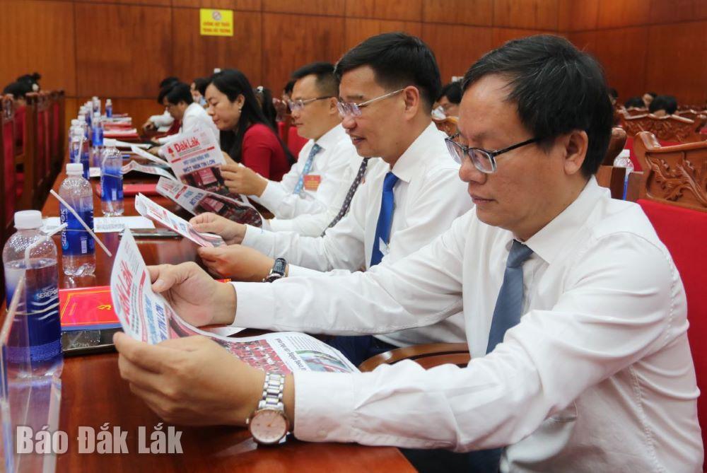 Các đại biểu đọc Báo Đắk Lắk tuyên truyền đại hội. Ảnh: Hà My