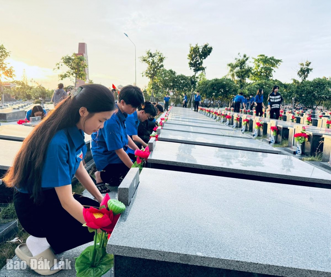 Đoàn viên, thanh niên thắp nến tại các phần mộ. Ảnh: Thùy Thảo